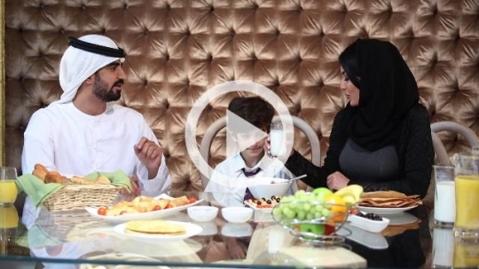 Arab father and mother sitting with their son during breakfast|