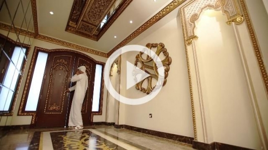 Middle Eastern man on the phone walking towards the door|