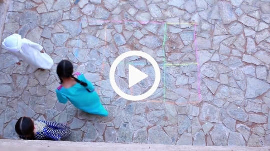 Top view of kids playing hopscotch outside