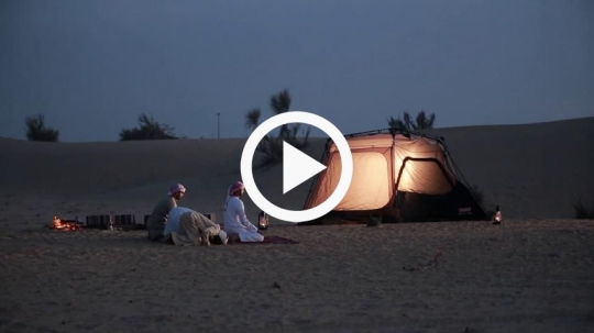 Men praying in the desert camp