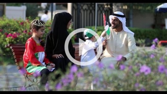 Middle Eastern family sitting on the bench representing the UAE |