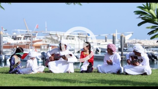 Arab family and friends sitting on the grass celebrating the UAE National Day|
