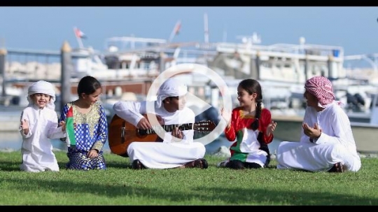 Arab family and friends sitting on the grass celebrating the UAE National Day|
