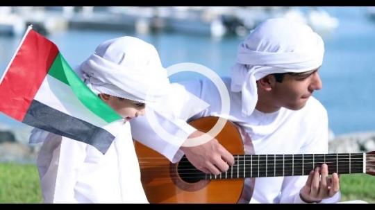 Arab family sitting on the grass celebrating the UAE National Day|