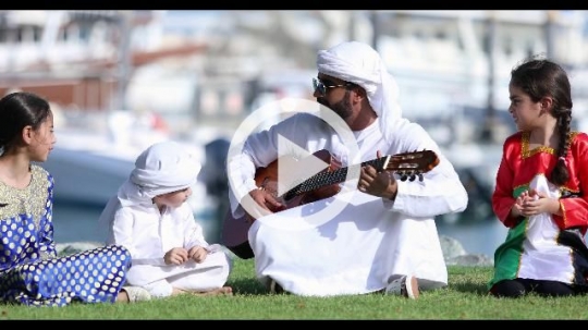 Arab family sitting on the grass celebrating the UAE National Day|