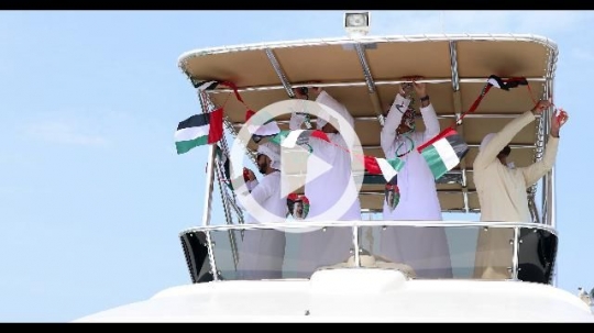 Emirati men dressed in the traditional UAE attire celebrating National Day|