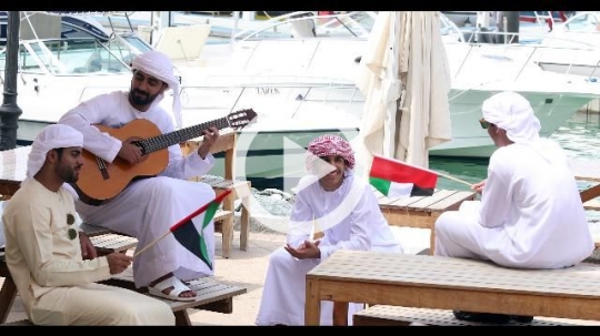 Emirati men sitting on the bench celebrating the UAE National Day |