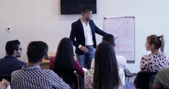 Woman raises her hand in class |-