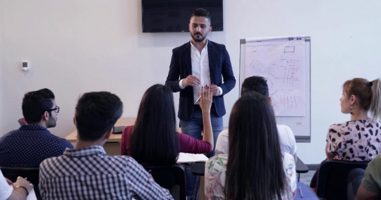 Student raising her hand to ask a question |-