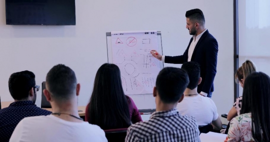 Students raises her hand to ask the professor a question |-