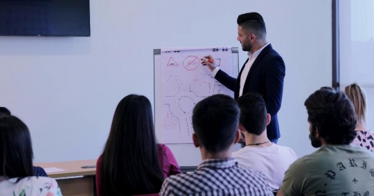 Students in the classroom listening to the professor |-