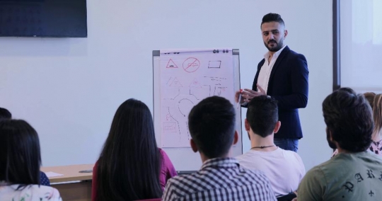 Middle Eastern professor talking to the students|-