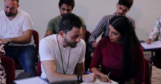 Students talking to each other in class|-