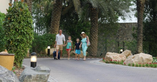Western couple with the kids leaving the resort|-