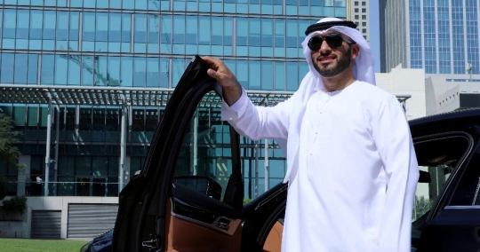Arab Businessman fixes his kandoura and closes the car door|-