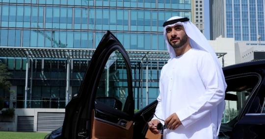 Middle Eastern Businessman standing by his car|-