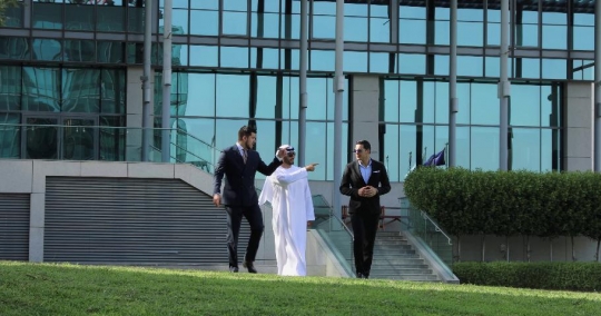 Businessmen walking together on the grass outside |-