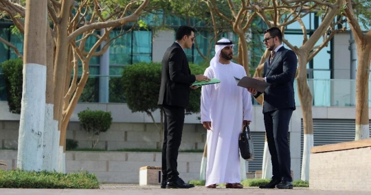 Middle Eastern Businessman walking towards colleagues |-