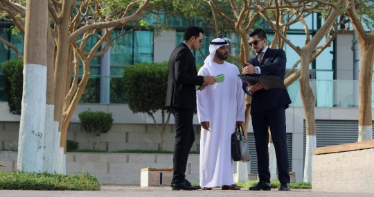 Middle Eastern Businessman standing talking to his colleagues|-