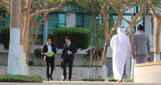 Western Businessman and Middle Eastern Businessman walking|-