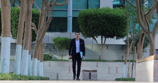 Middle Eastern Businessman walking and drinking coffee|-