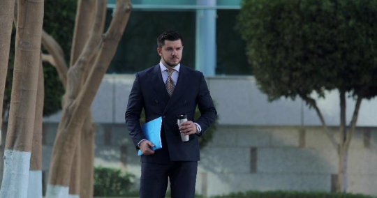 Western Businessman drinking a hot drink walking|-