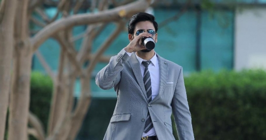 Businessman walking drinking coffee|-