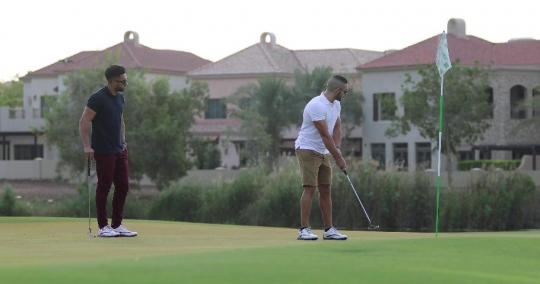 Middle Eastern men playing golf|-
