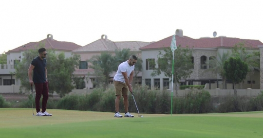 Middle Eastern man playing golf|-