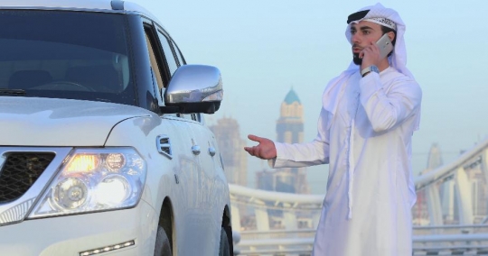 Arab Businessman talking on the phone explaining his car|-