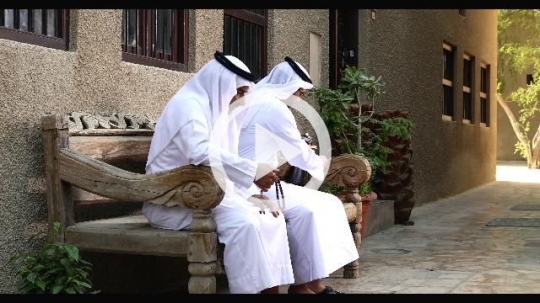 Arab son walking towards his father sitting on the bench|