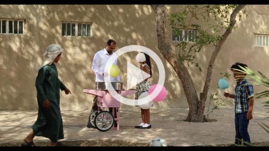 Arab man offering cotton candy to the young boys|