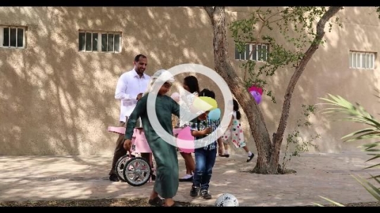 Middle Eastern man offering cotton candy to the kids|