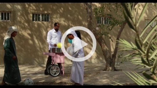 Middle Eastern offering the kids cotton candy|