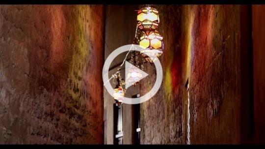 Arab girl running through the alleyway decorated by Ramadan Lanterns|