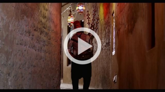 Middle Eastern Ramadan Drink Seller walking through the pathway of Ramadan Lanterns|