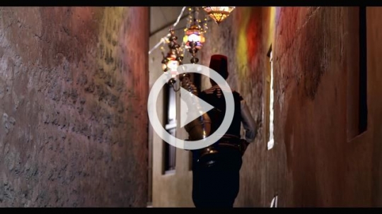 Middle Eastern Ramadan Drink Seller walking through the alleyway decorated by Ramadan Lanterns|