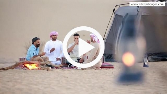 Friends having arabic coffee outside tent