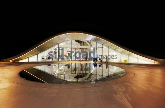Futuristic Dubai Building with Reflective Water Feature at Night