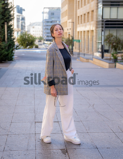 Professional Woman Smiling and Reflecting on Business Opportunities in Al Abdali, Amman Boulevard