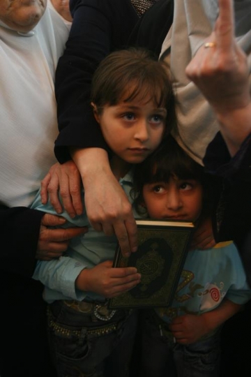 little girl with mother holding holy quran