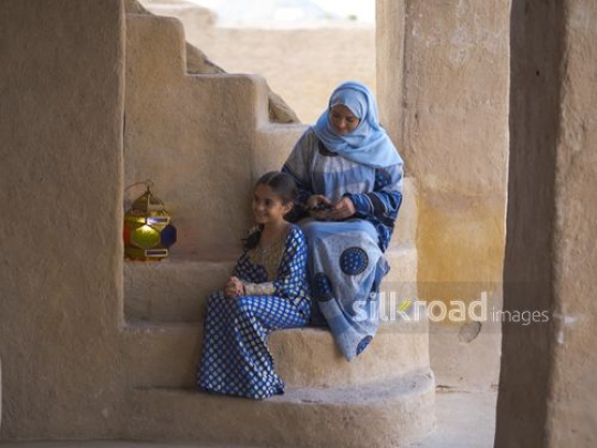 Mother making braids for daughter|-