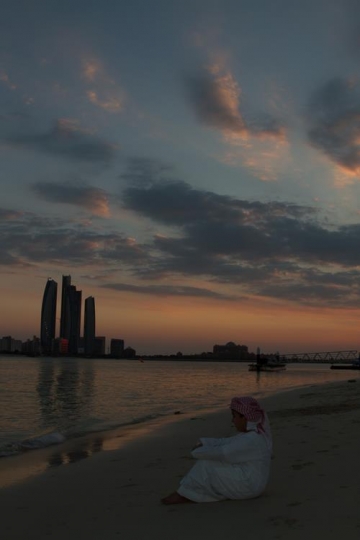 kid sitting by the beach after sunset