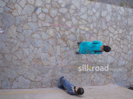Sisters playing hopscotch|-