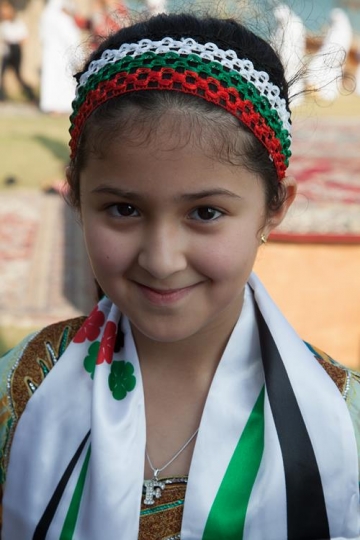 little girl looking at a camera wearing a scarf