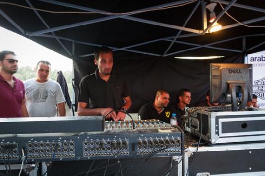 photo of adult dj working with his equipment