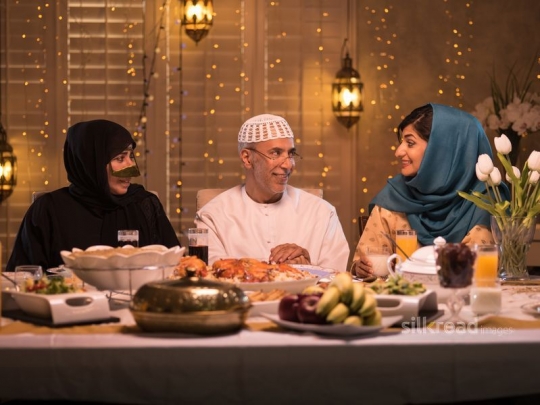 Parents with daughter talking over meal|-