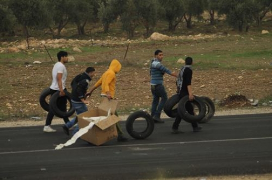 palestinian youth carrying tires