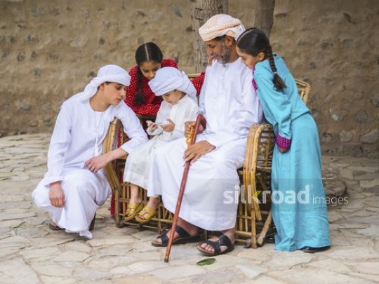 Kids gathered around grandfather|-