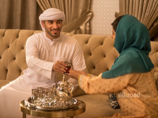 Wife serving husband Arabic tea|-
